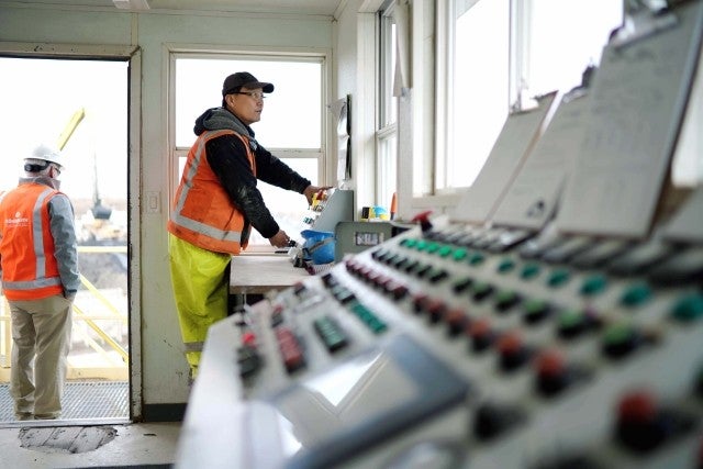 Man operating controls in the control tower of worksite