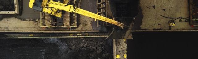 bulldozer processing dredged material on a barge