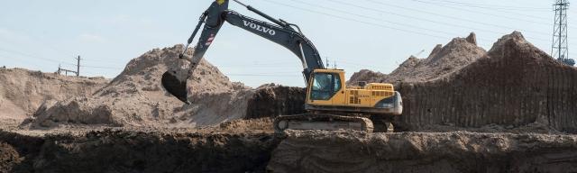 Excavator moving dirt on work site 