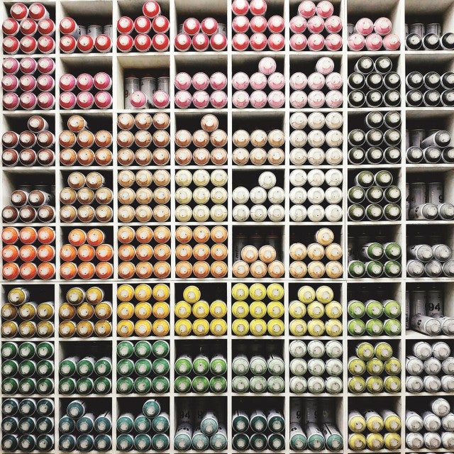 aerosol paint cans stacked on shelves 