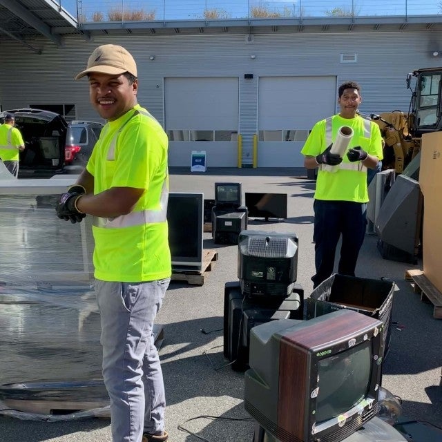 Team at collection event wrapping pallets of televisions recycling 