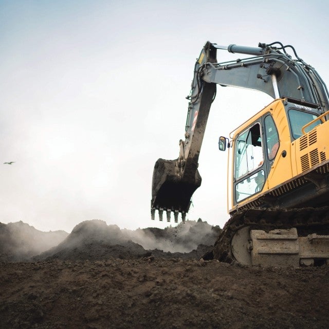 Excavator moving stockpile 