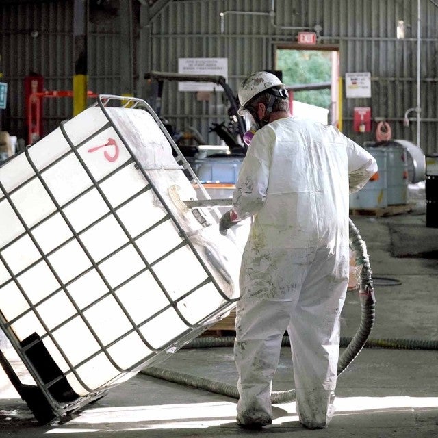 person in PPE cleaning tote