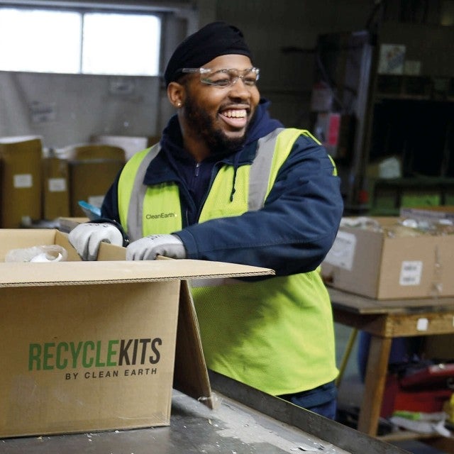 man unloading boxes of lamps for recycling