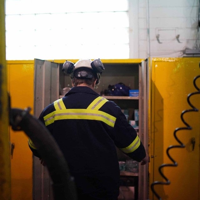 Back of person in PPE at locker 