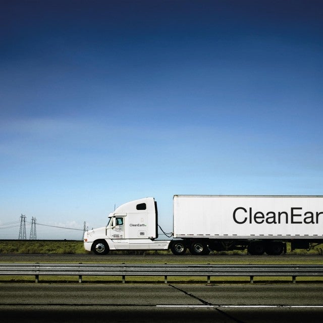 Clean Earth truck driving with blue sky in the background 