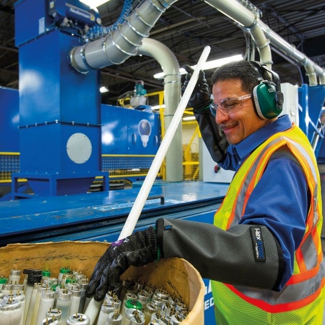 man emptying barrels of fluorescent bulbs