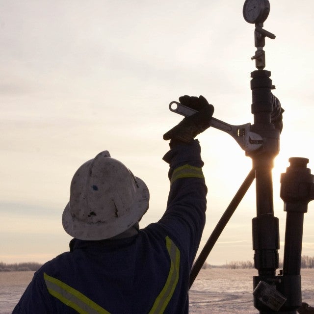 Person working at pipeline and drill site 