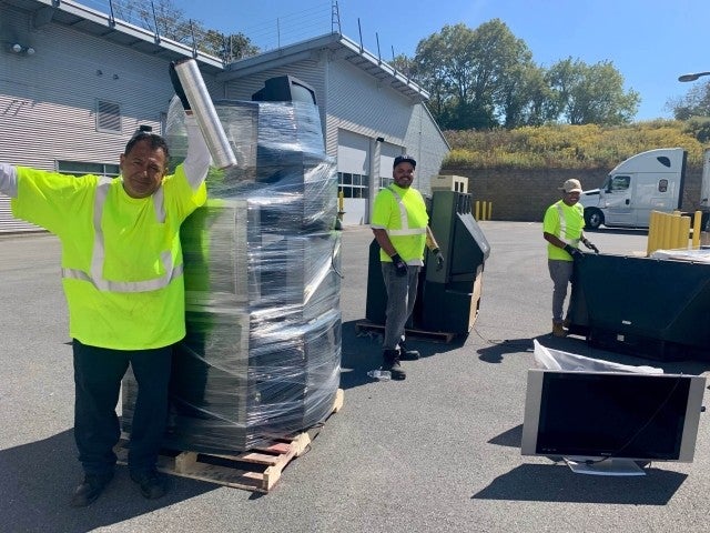 Team at collection event shrink wrapping pallets for recycling 