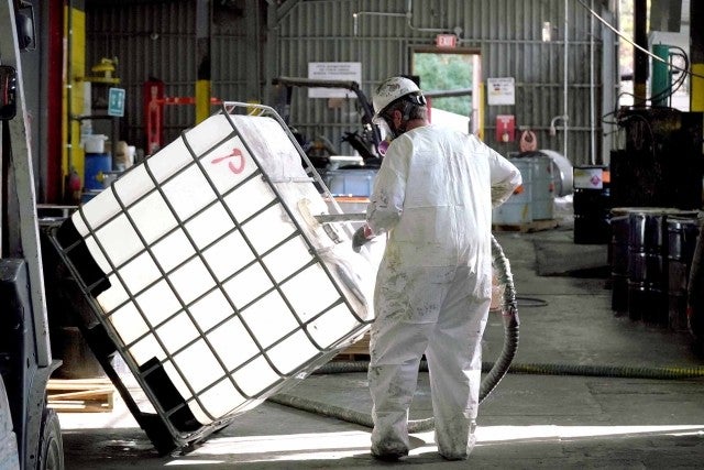 person in PPE cleaning tote