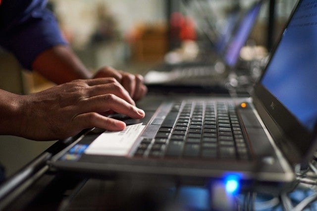 hands typing on laptop keyboard