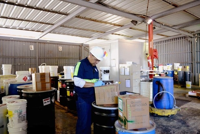 man packing lab chemicals in warehouse