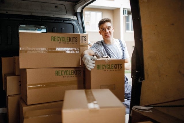 man unloading van of boxes for recycling